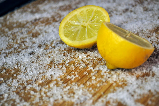 Clean wooden and bamboo cutting boards with kosher salt and lemon.