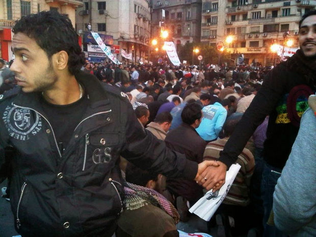 29 Powerful Pictures - Christians protecting Muslims during prayer during the 2011 uprisings in Cairo, Egypt.