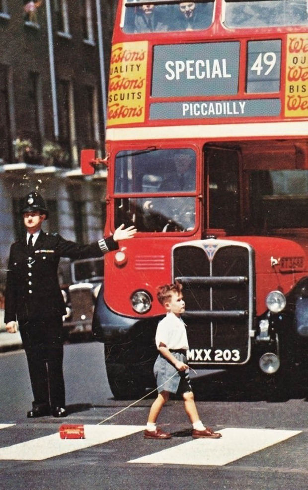 29 Powerful Pictures - A boy pulling his toy double-decker across a London street in the 1960's.