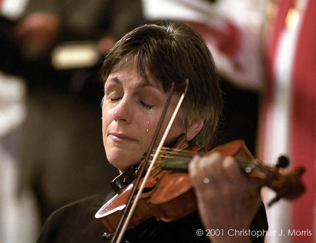 29 Powerful Pictures - Nancy Dinovo, a violinist, cries while playing during a service at Christ Church Cathedral in downtown Vancouver for the victims of 9/11.