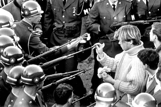 29 Powerful Pictures - A Vietnam War protester inserting flowers into National Guardsmen's rifle barrels.