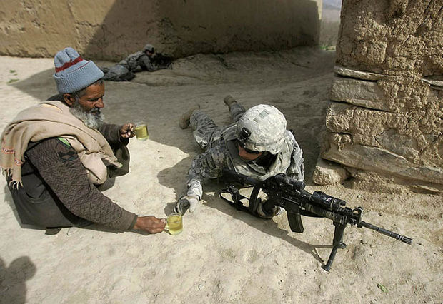 29 Powerful Pictures - An Afghan man offers tea to soldiers.
