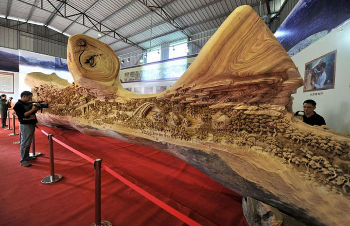 The sculpture is based on the Chinese painting 'Along the River During the Qingming Festival'. It was created over 1,000 years ago and Chunhui captured all of its intricate details in his tree trunk carving.