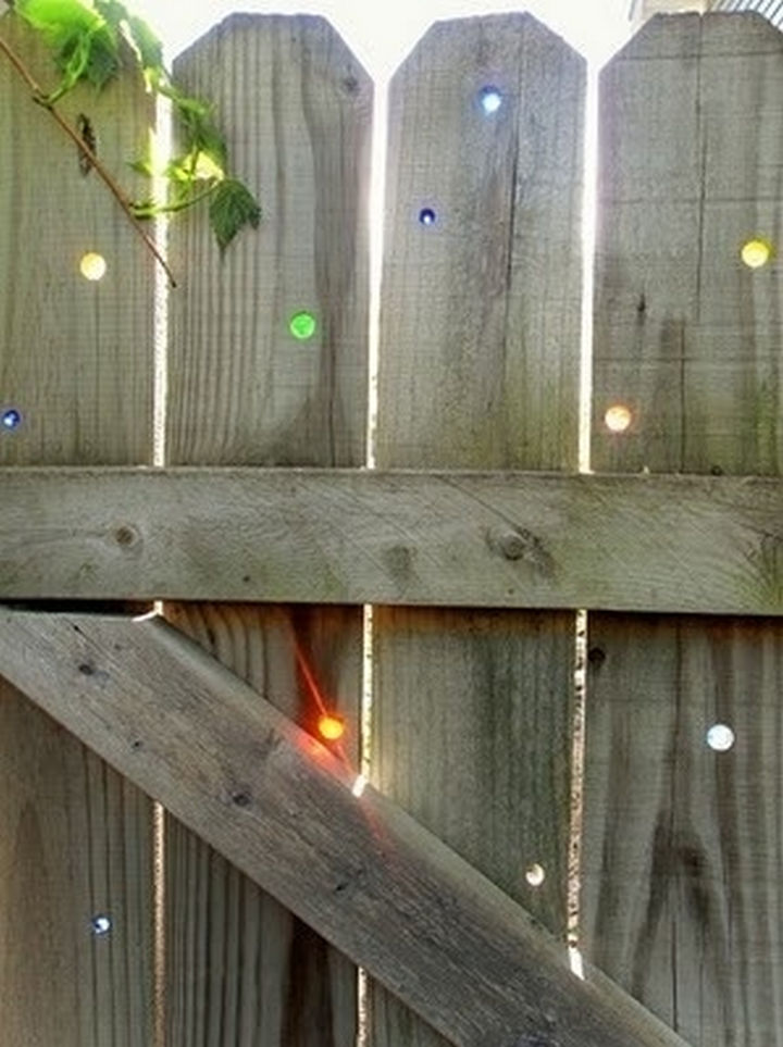 34 DIY Backyard Ideas for the Summer - Put marbles in your fence to fill any holes in your wooden fence.