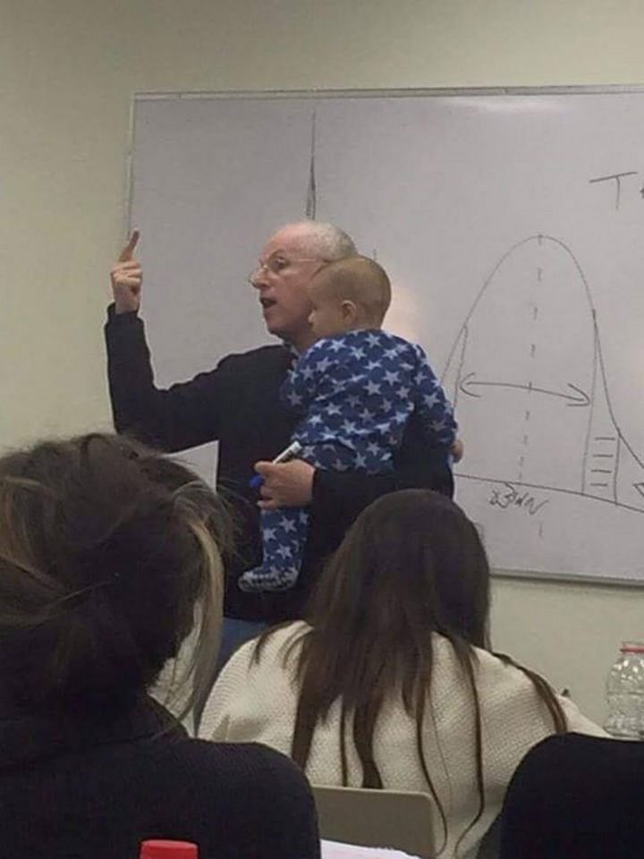 When a student's baby began crying in class, Dr. Sydney Engelberg of Jerusalem's Hebrew University, quickly comforted the baby. The professor holds a baby and continues teaching.