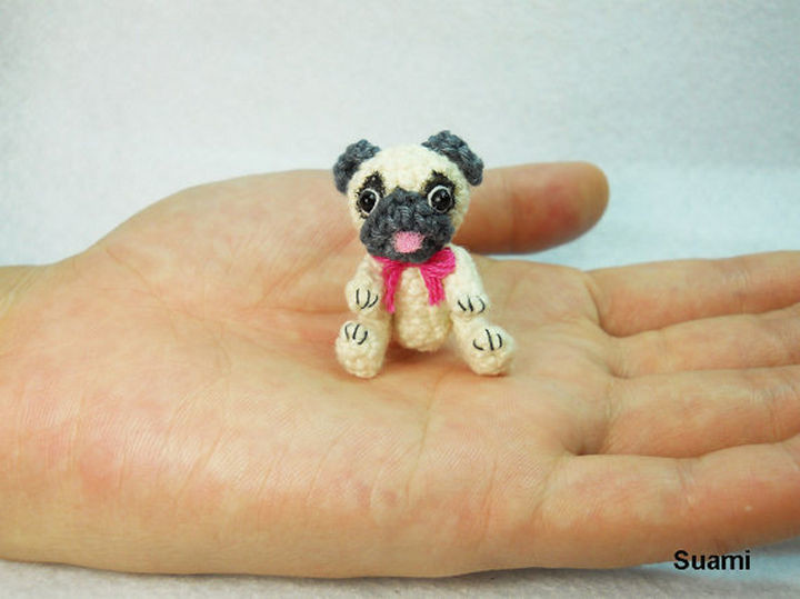 Tiny crochet Pug with a pink bow.
