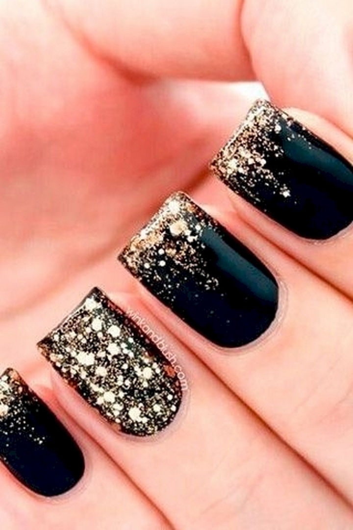 22 Black Nails That Look Edgy and Chic - Glossy black with a gold glitter fade.