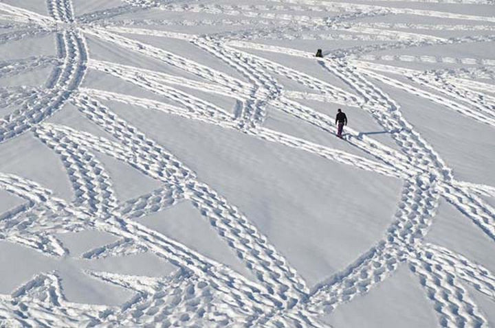 Simon walks through the snow with a variety of snowshoes to create his masterpieces.