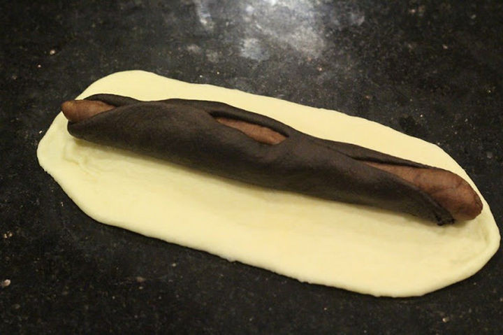 The darker colored dough wraps around the lighter colored dough. Then repeat the process with the white dough.