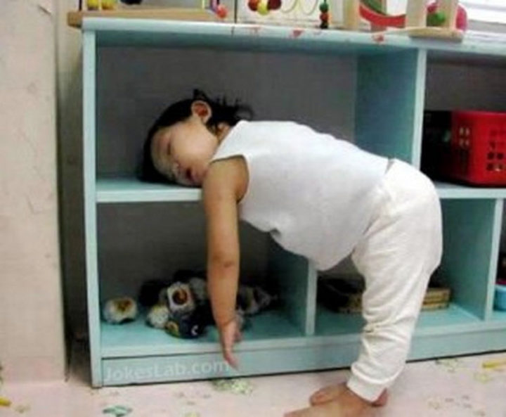 25 Kids Sleeping in the Strangest Places - A bookshelf is the perfect place for a nap.
