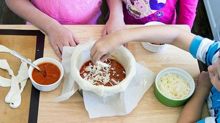 Here comes the fun part so ask your kids to help. Spread a little pizza sauce over the bottom layer, followed by some pepperoni, and finally some shredded mozzarella cheese.