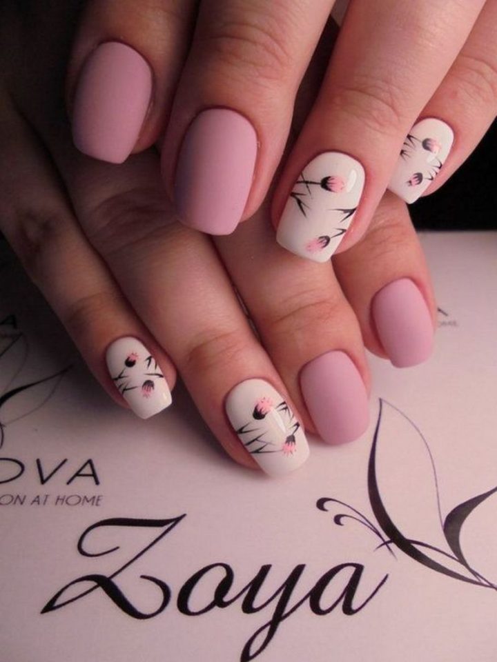 Beautiful matte pink manicure with delicate flower designs.